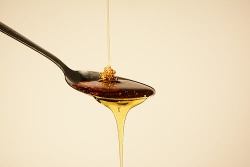 Honey Flowing through Spoon