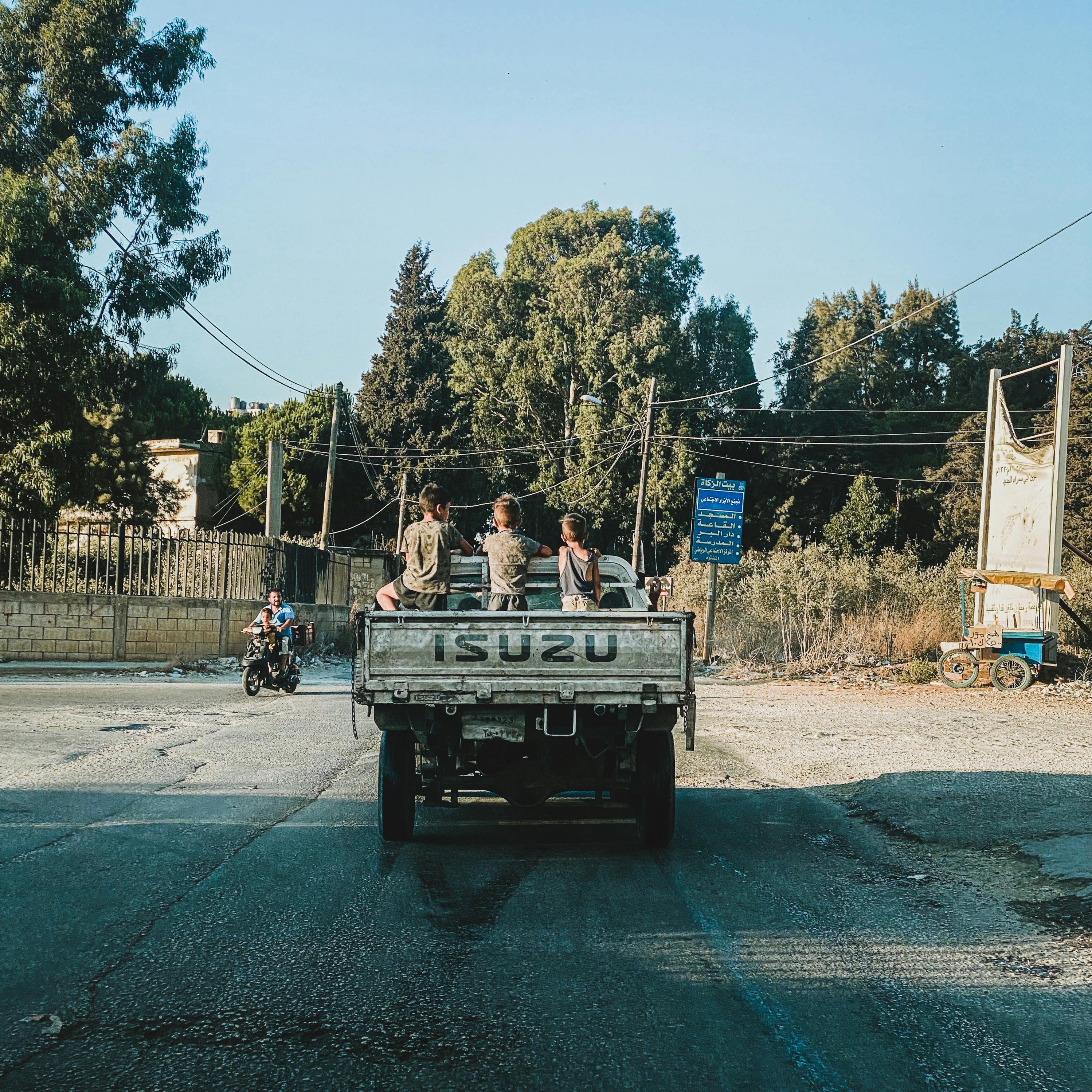 Children Standing on Trunk of Isuzu Truck
