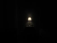 Lamp glowing on a nightstand in a dark room, photo by Dorran on Pexels