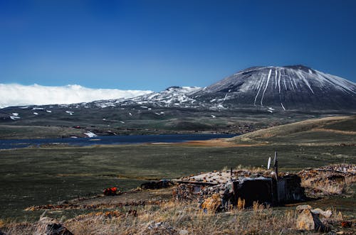 Landscape of a Snowcapped Hill and Hut in the Valley 