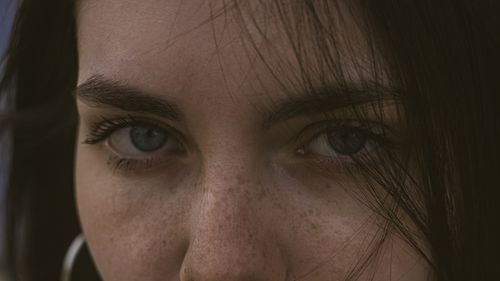 Free Detailed close-up of a woman's eyes and freckles, highlighting natural beauty. Stock Photo