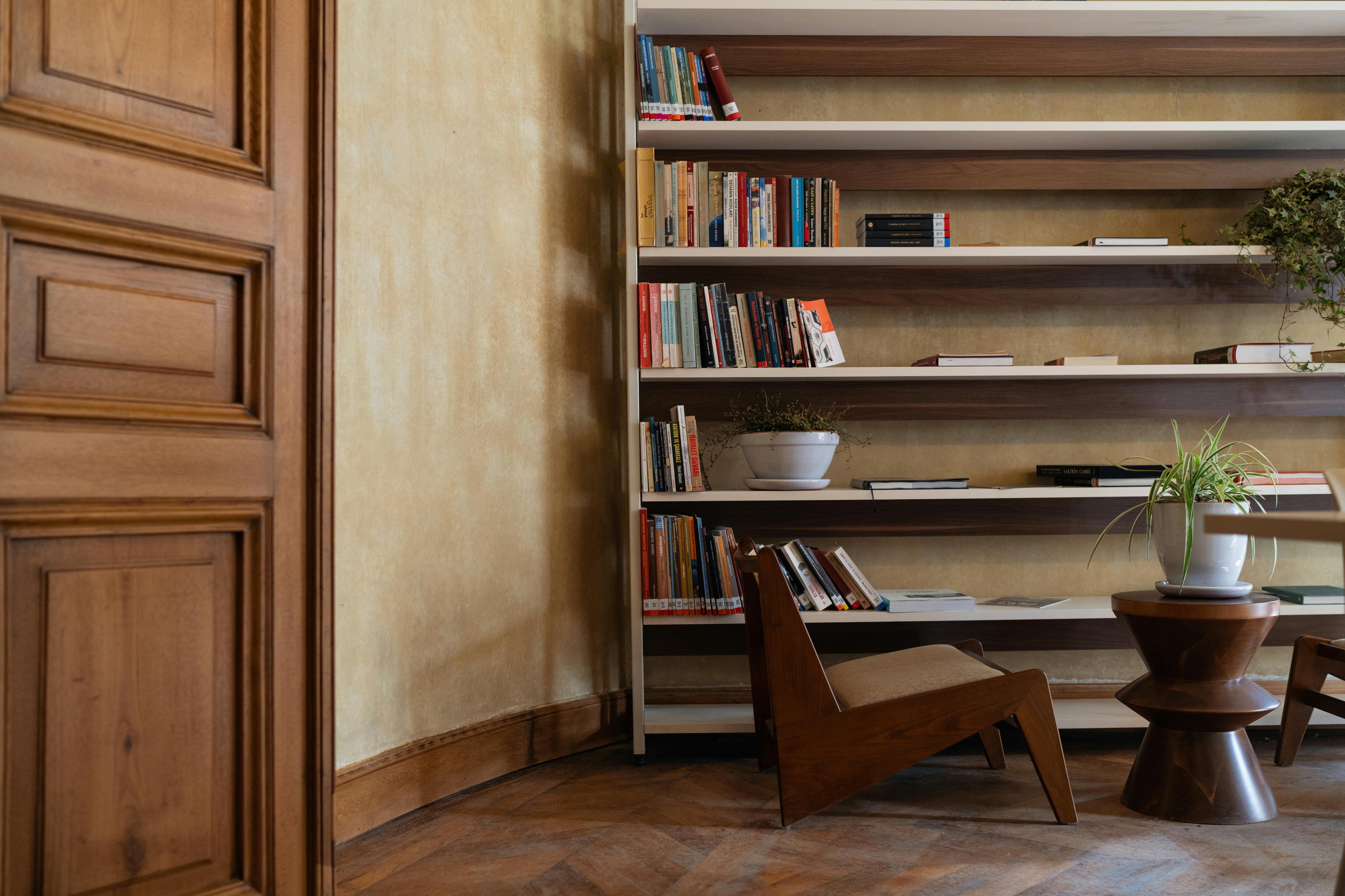 Books on Shelves behind Chair · Free Stock Photo