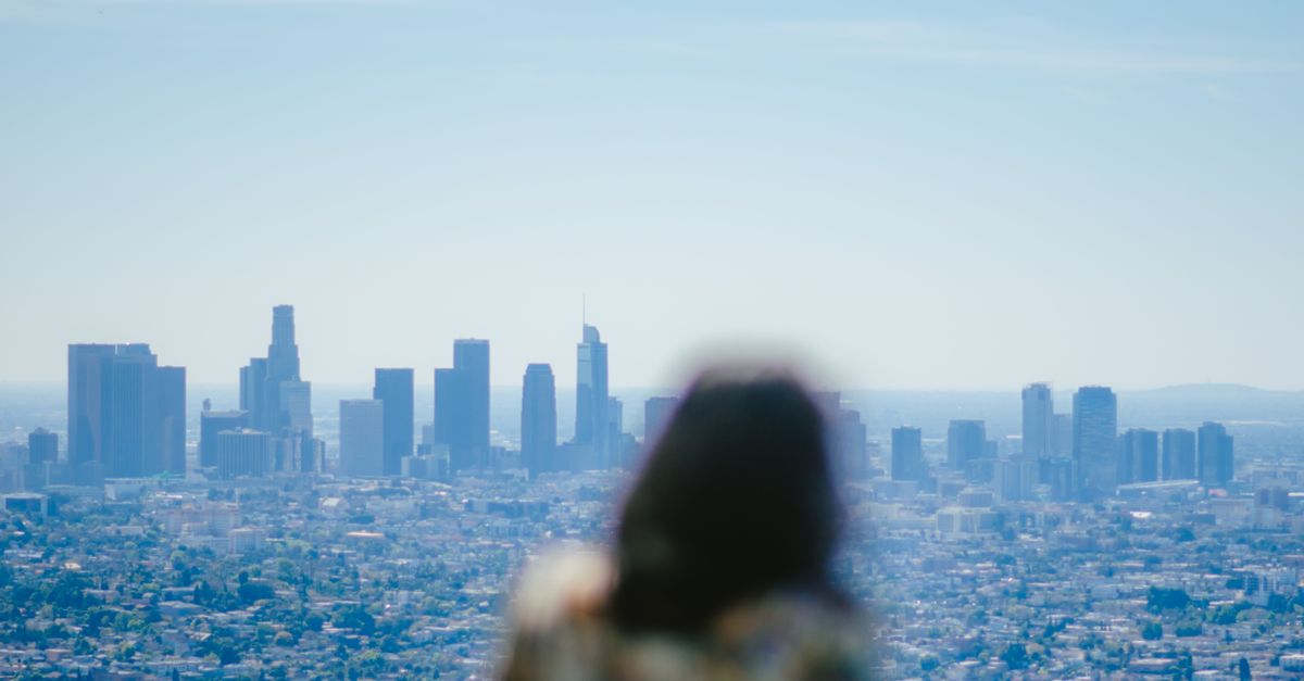 Vibrant summer view of Los Angeles skyline with a person in the foreground, capturing urban life.