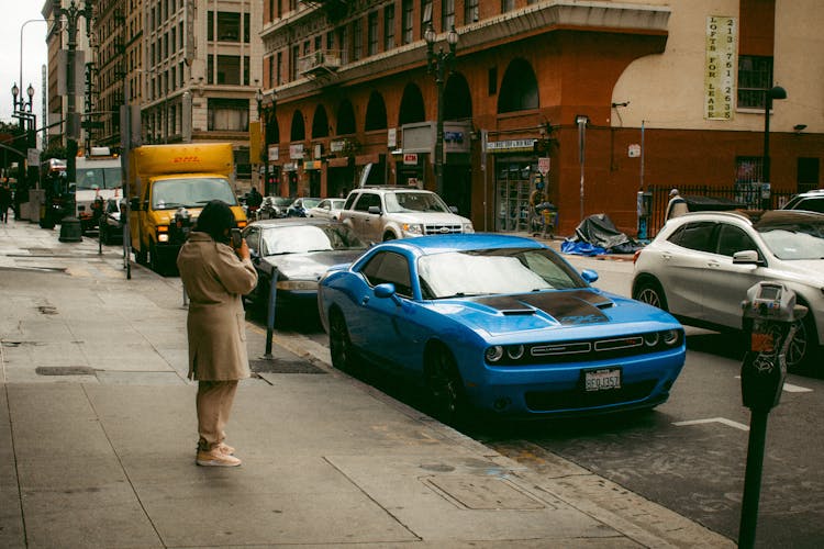 Tourist Taking A Picture Of A Blue Dodge Challenger