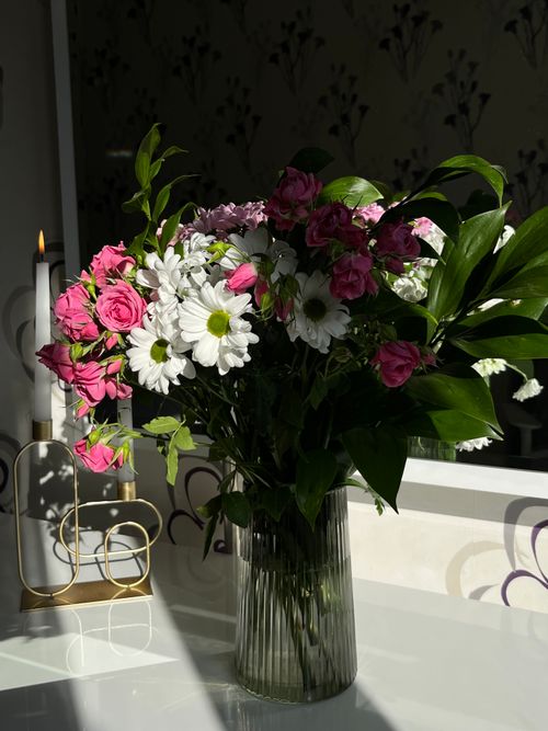 Free A beautiful bouquet of flowers in a glass vase with natural lighting. Stock Photo