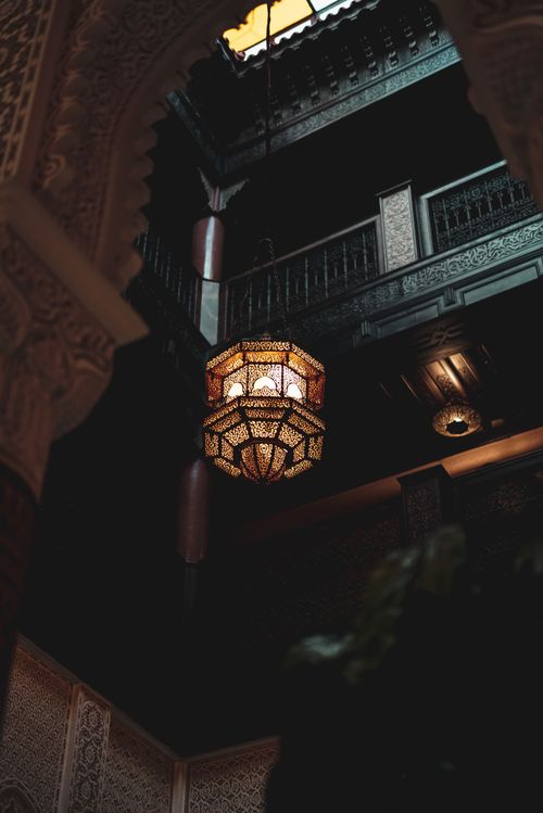 Free Intricate Moroccan interior featuring a stunning hanging lamp and detailed archways. Stock Photo