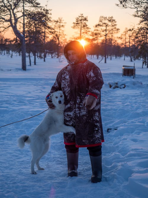 Woman Hugging Dog in Winter at Sunset
