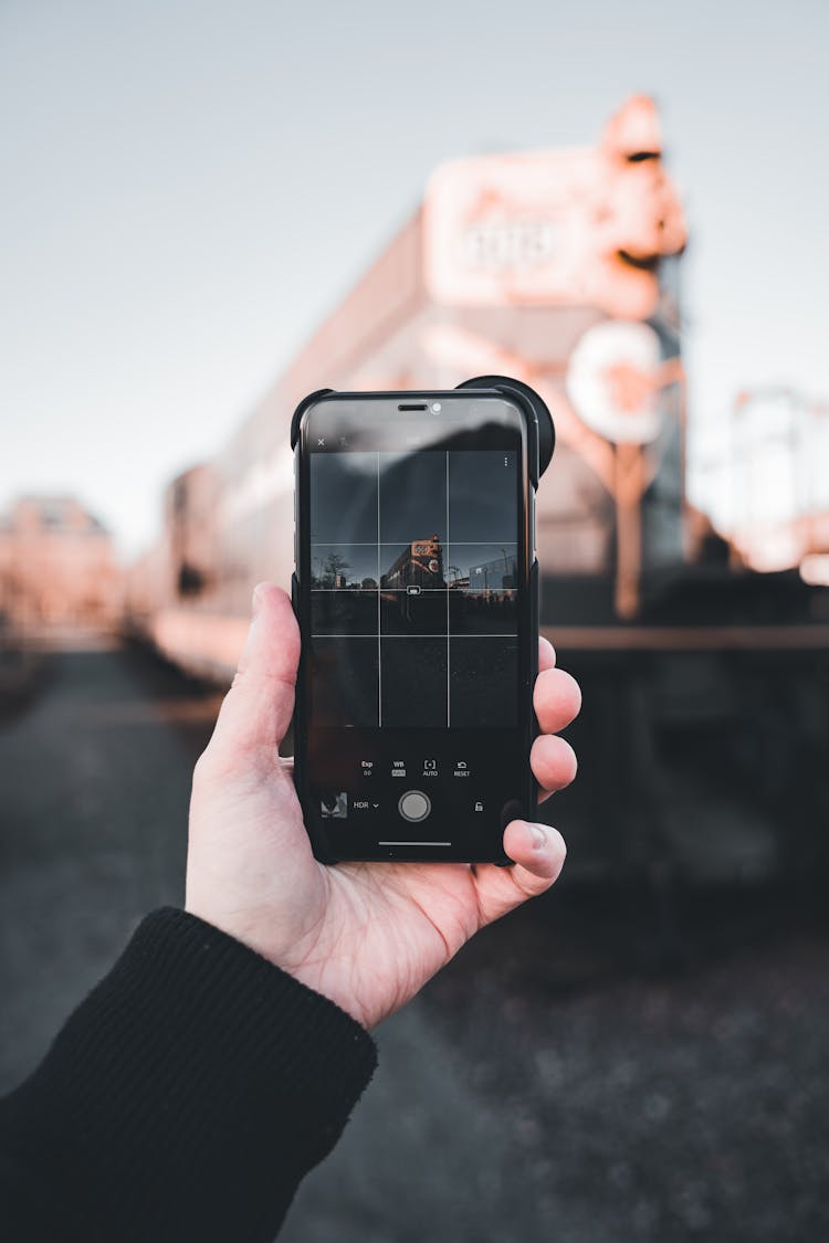 Hand Holding Cellphone And Taking Picture In City