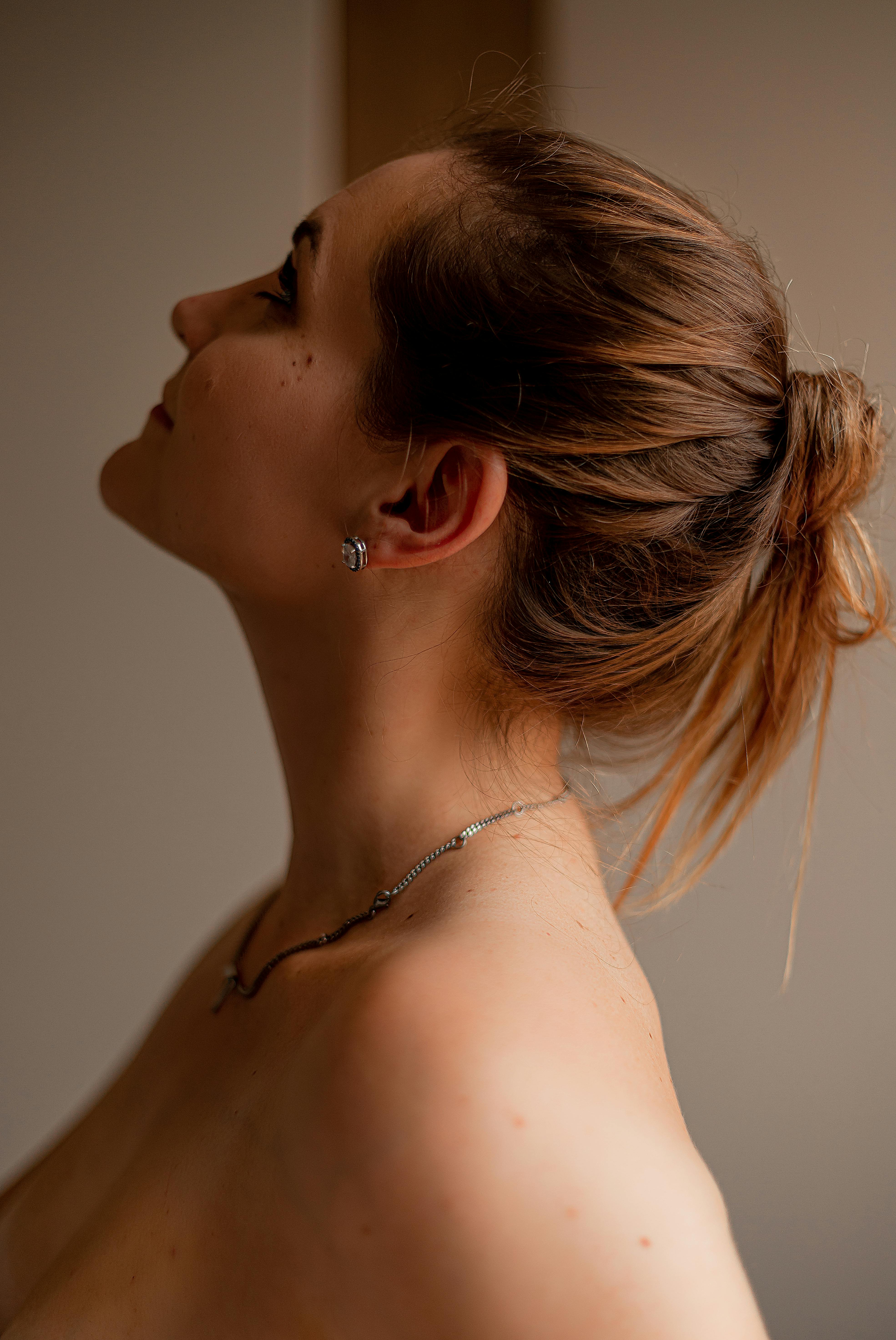 Elegant side profile of a woman with brown hair in an indoor setting, Brazil.