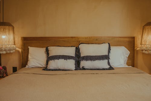 Foto profissional grátis de almofadas, arrumado, cama