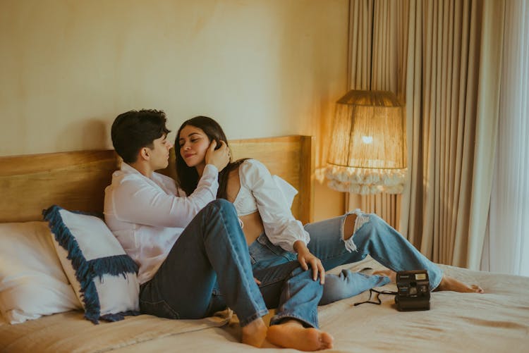 Affectionate Couple Together In Bedroom With Polaroid Camera