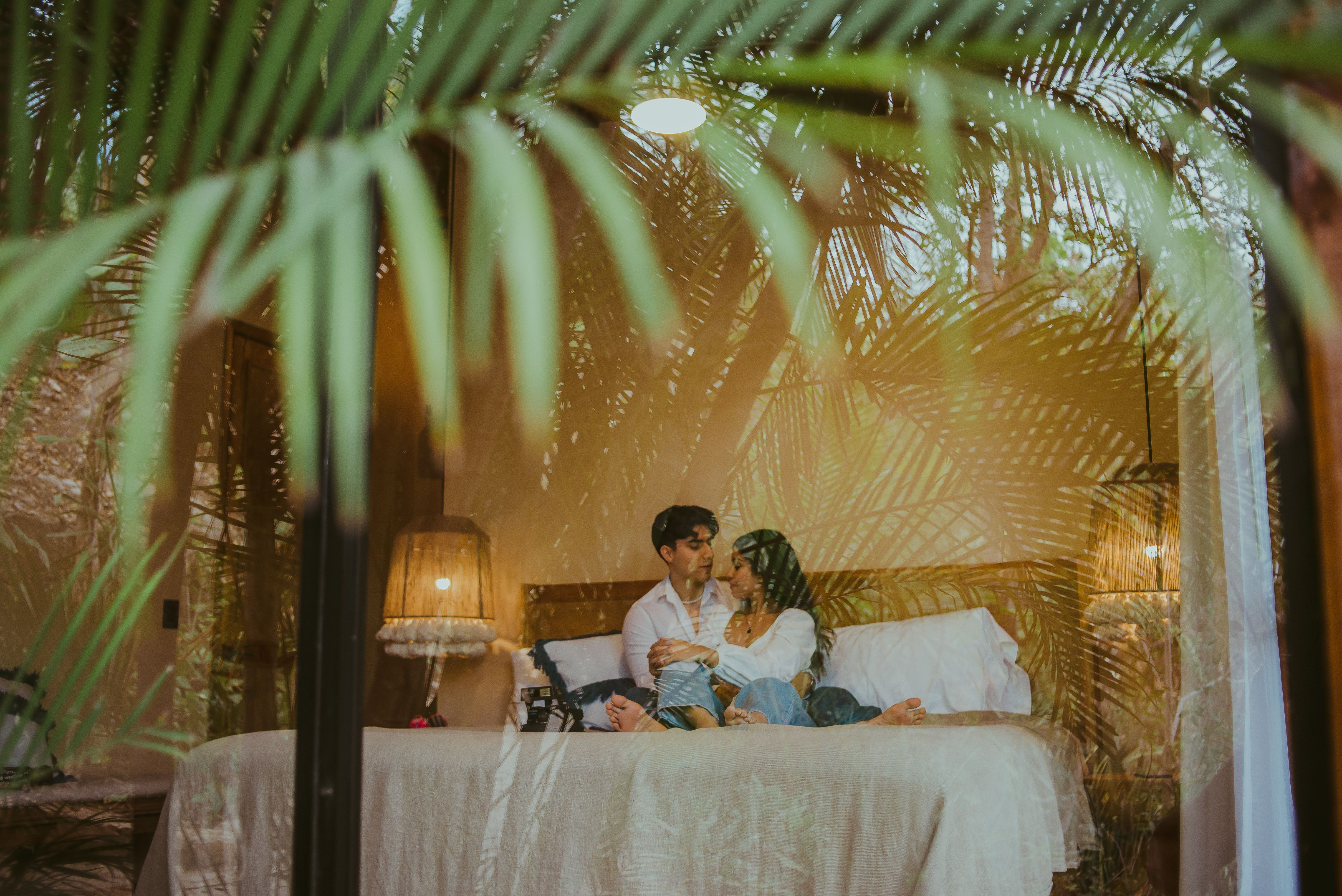 Casal se abraça em quarto de hotel luxuoso, celebrando romance e privacidade.