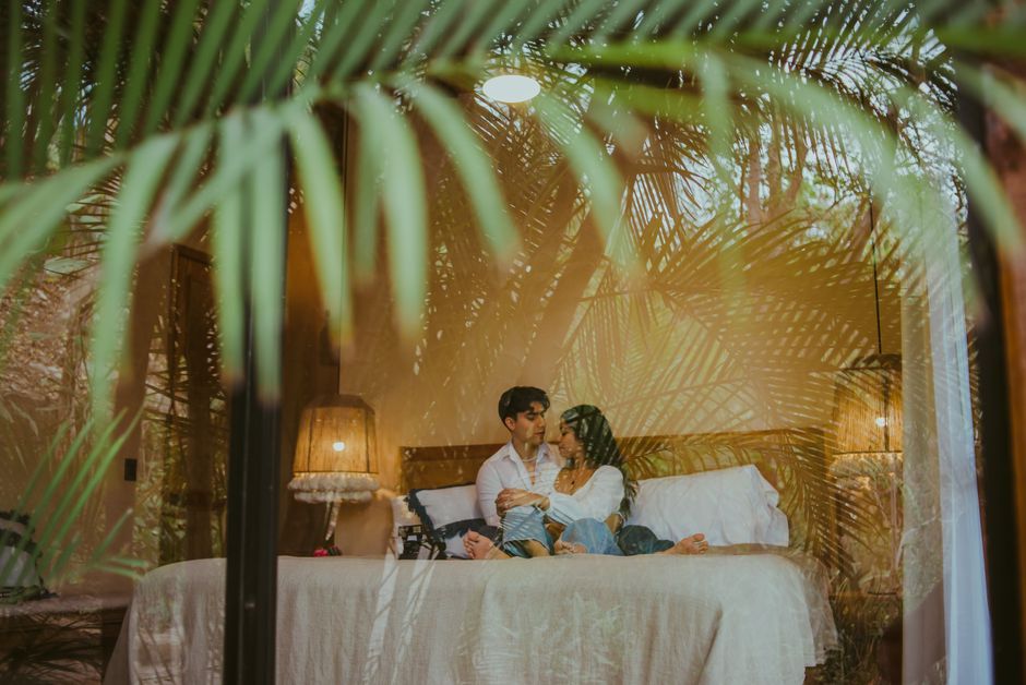 Casal se abraça em quarto de hotel luxuoso, celebrando romance e privacidade.