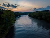 日出时分，俯瞰密苏里州霍利斯特一条树木繁茂的宁静河流，捕捉到大自然的宁静