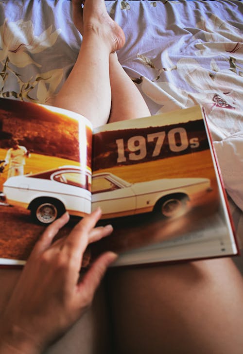 Free Person Holding Car Book on His Lap Stock Photo