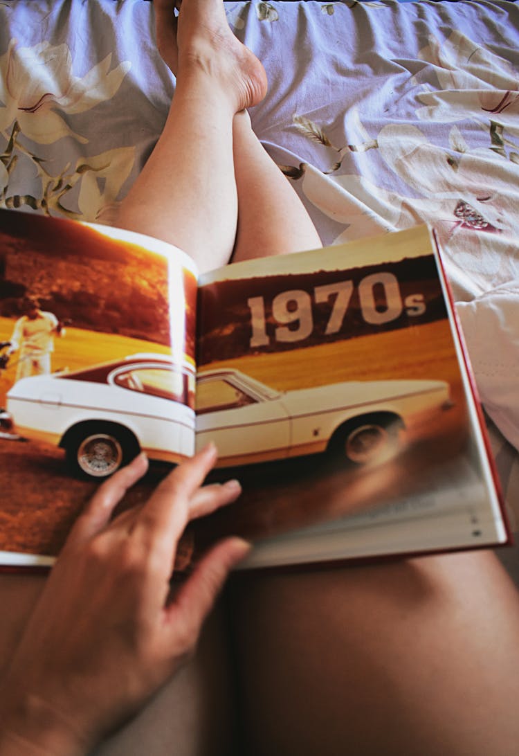 Person Holding Car Book On His Lap