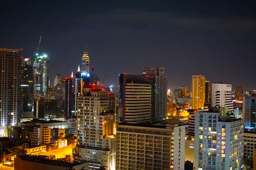 Free Dynamic cityscape featuring illuminated skyscrapers against the night sky, rich in urban life. Stock Photo