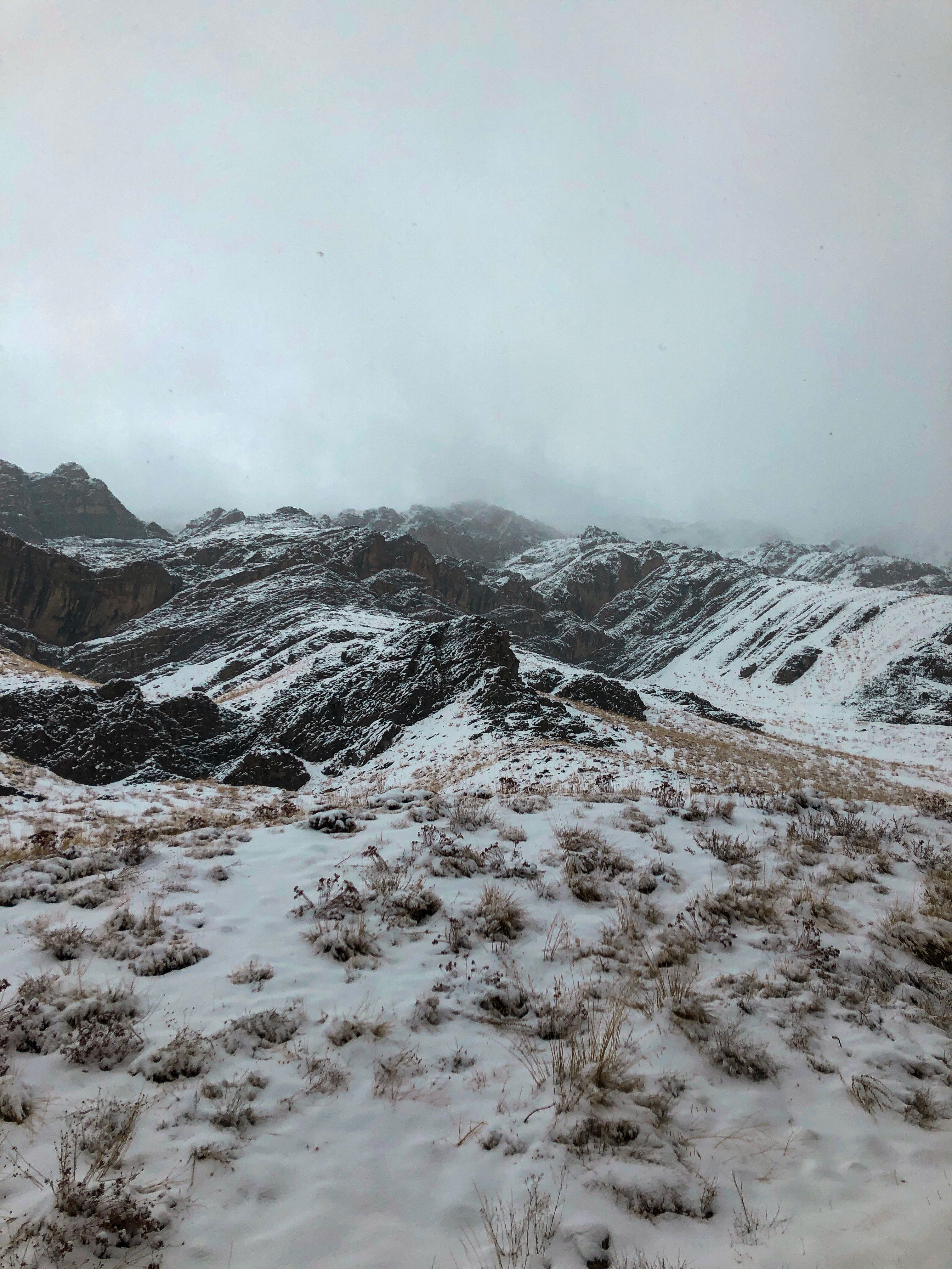 Overcast over Rocks on Hills in Snow · Free Stock Photo