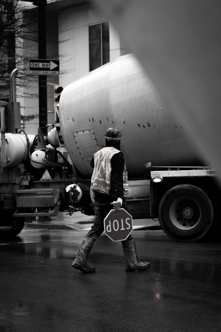 Worker In Reflective Vest And With Stop Sign