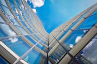 低角度拍摄的现代玻璃摩天大楼映照着天空和云层