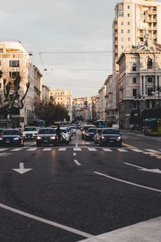 Traffic flows through a bustling city street in Trieste, Italy, showcasing urban life.