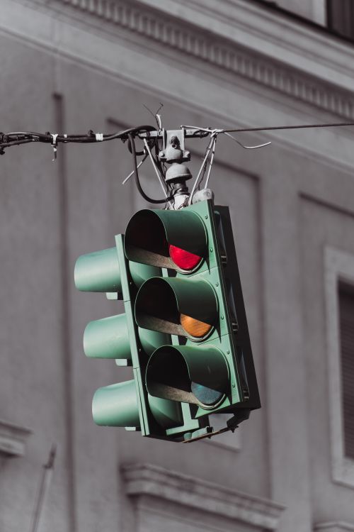 Free Close-up of an urban traffic light showing red in a city setting with a building background. Stock Photo