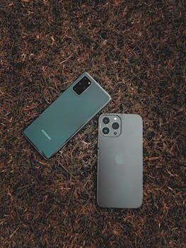 Top view of Samsung and iPhone placed on a grassy surface, showcasing modern smartphone design.