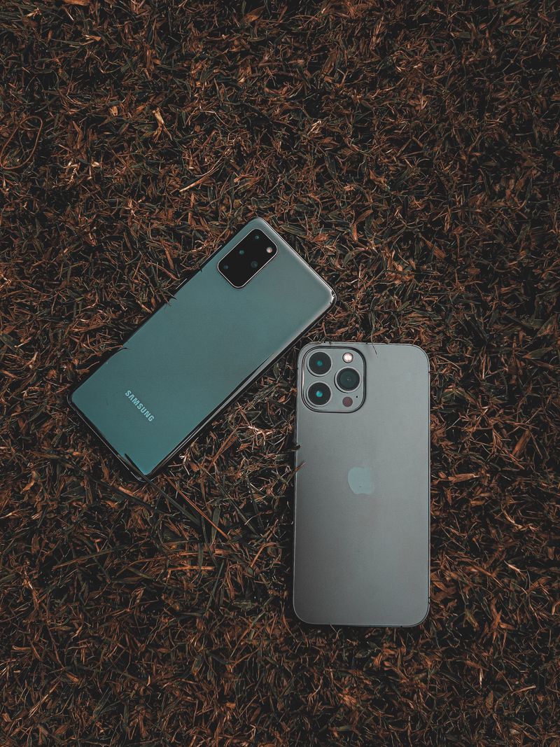 Top view of Samsung and iPhone placed on a grassy surface
