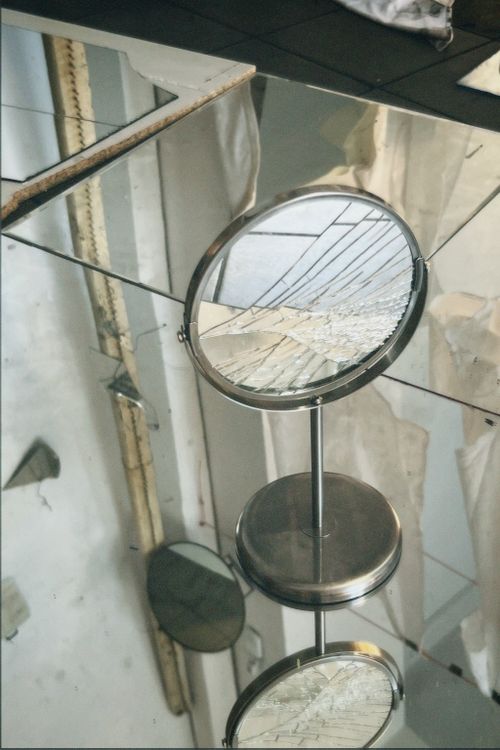 Free Capture of a broken mirror reflecting an architectural structure, adding depth and abstract art. Stock Photo