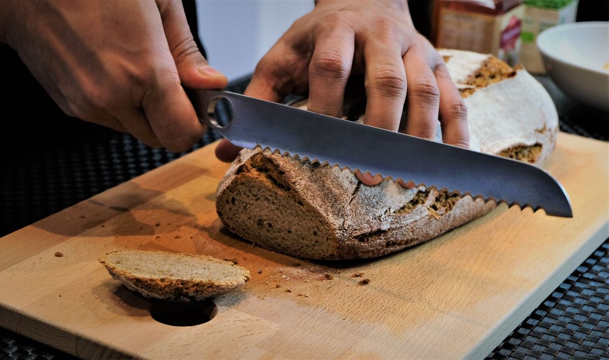 Keeping serrated blades sharp makes for cleaner, safer cuts Person slicing bread with a serrated knife on a cutting board