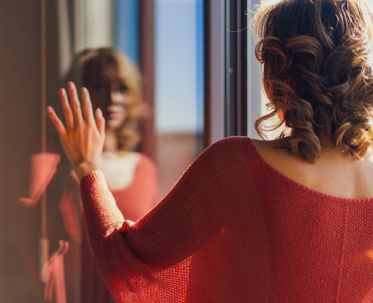 Back View Of Woman In Red Clothes And Reflection In Mirror