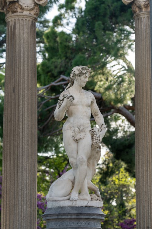 A Statue between Columns in the Park El Capricho Alameda de Osuna, Madrid, Spain 