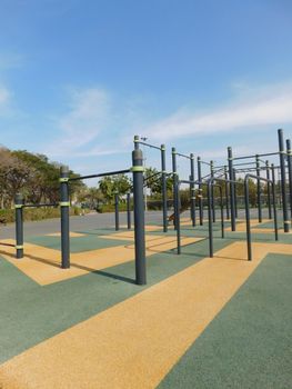 Outdoor fitness area with pull-up bars and exercise equipment on a clear, sunny day.