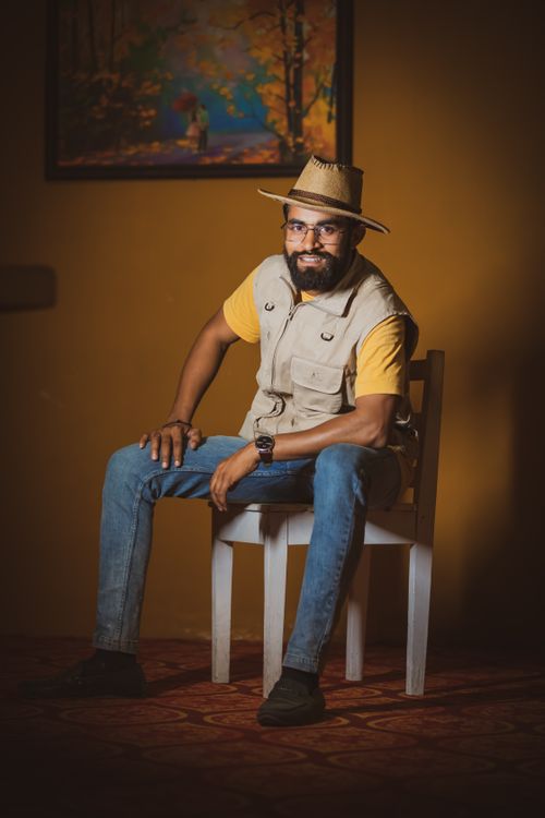 Free A bearded man in a cowboy hat sitting indoors on a chair, exuding a vintage style. Stock Photo