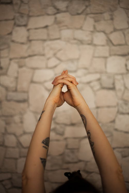 Clasped Hands of a Tattooed Person