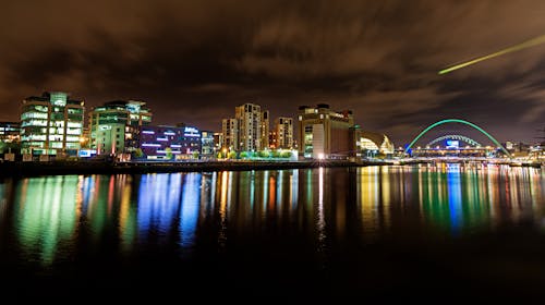 grátis Paisagem Urbana à Noite Refletindo No Corpo D'água Foto profissional