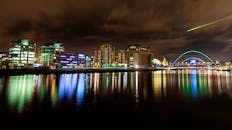 五颜六色的灯光和一座现代化的桥梁上，映照着夜晚充满活力的城市天际线