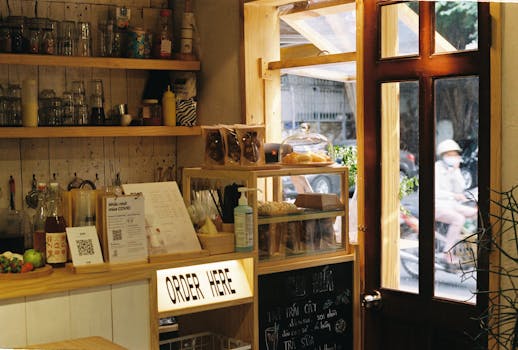 Warmly lit bakery interior with various baked goods displayed near a sunny entrance.