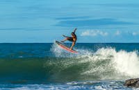 在阳光明媚的日子里，冲浪者展示着动态的空中机动技巧