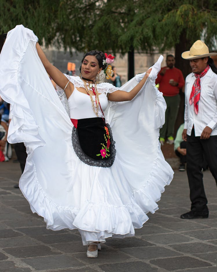 Young Woman In A Traditional Dress Dancing At A Parade 