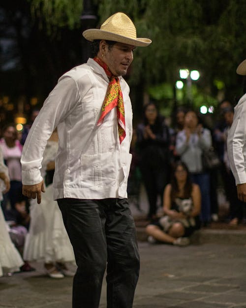 Man in Traditional Clothing Dancing on the Street at a Parade 