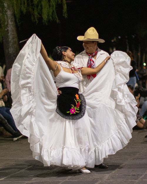 Free A couple elegantly performs a traditional dance in vibrant attire during a cultural festival. Stock Photo
