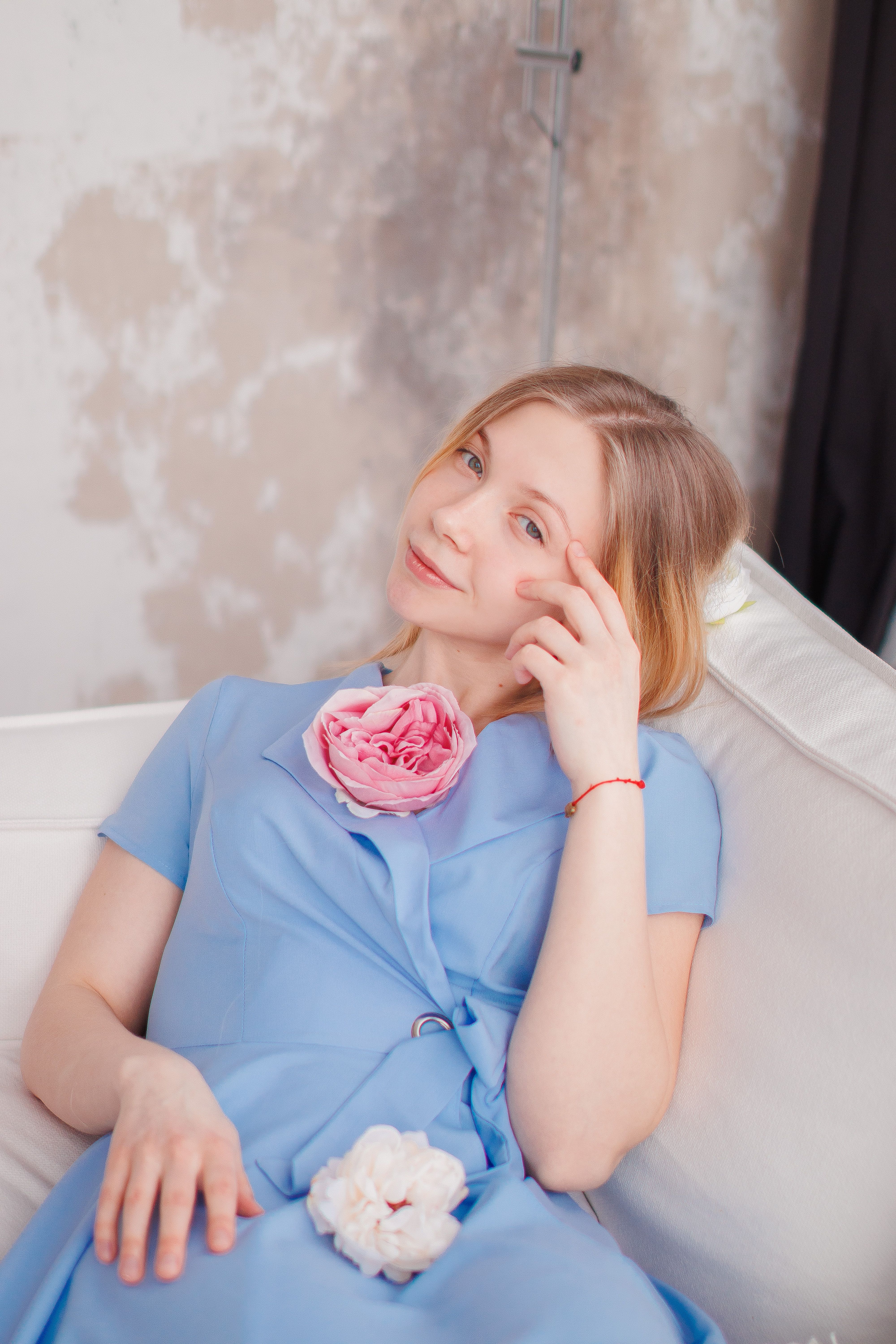 Young Woman in a Blue Dress Sitting on a Sofa · Free Stock Photo