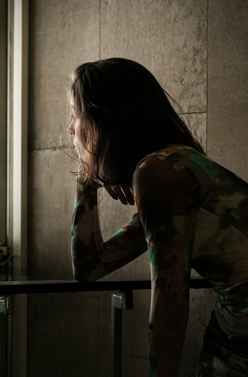 Woman with Long Hair Leaning on Railing near Wall