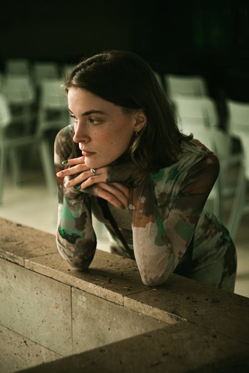 Pensive Woman Posing near Stone Wall