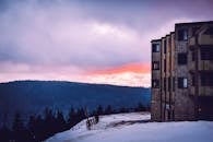 日落时分，雪覆盖的山峦和乡村建筑构成了一幅令人惊叹的冬日风景