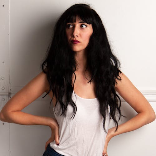 Woman Holder Her Waists While Leaning On White Wall