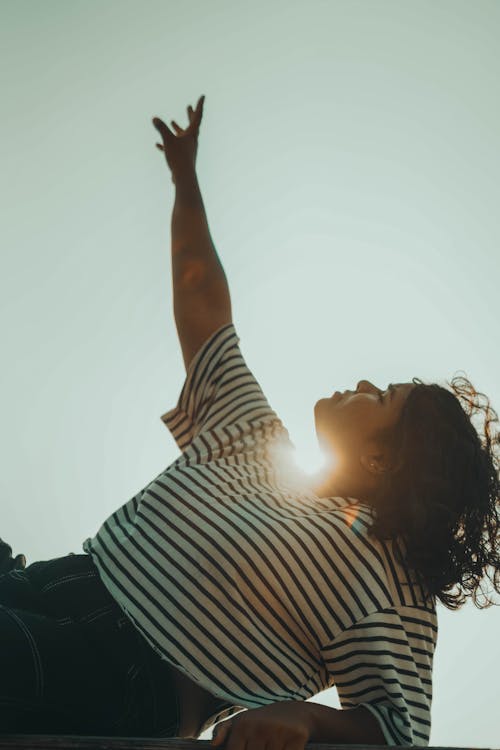 Sunlight over Woman Posing with Arm Raised