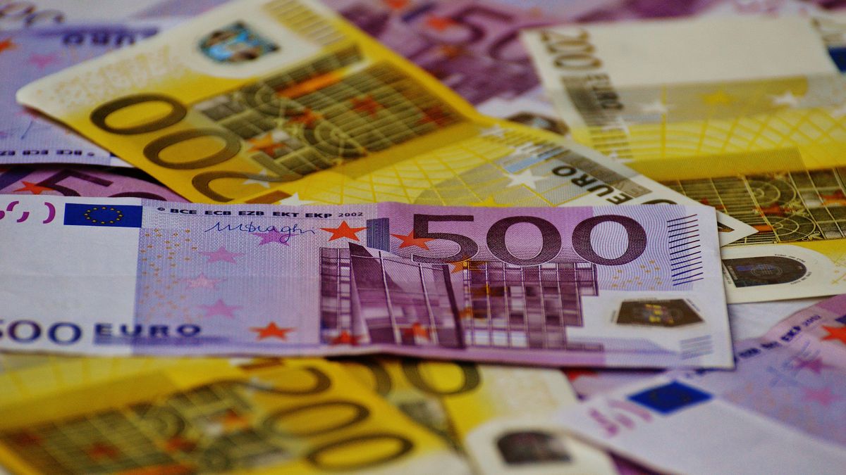 A close-up image of several Euro banknotes arranged in a scattered manner.
