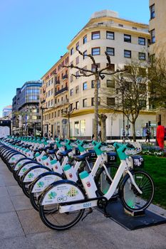Row of bicycles for rent at a bustling city bike station, perfect for exploring urban areas.